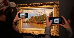 People taking photographs of a Monet painting